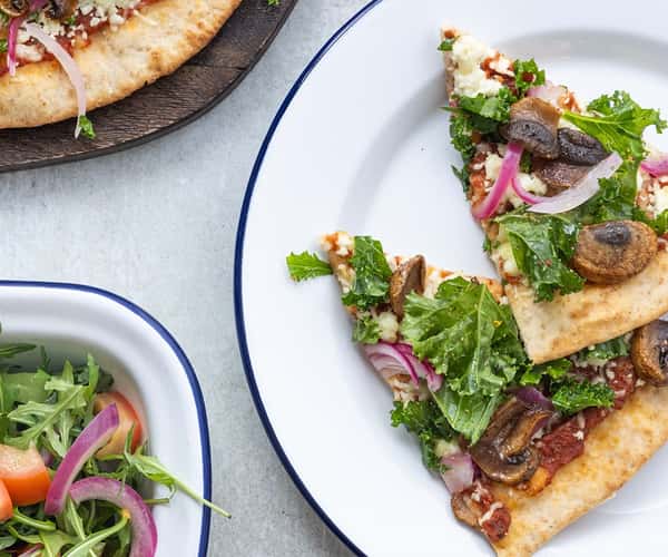 Fullkornspizza med skjørost, sprø grønnkål, sopp, og syltet rødløk