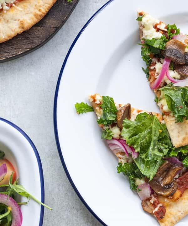 Fullkornspizza med skjørost, sprø grønnkål, sopp, og syltet rødløk