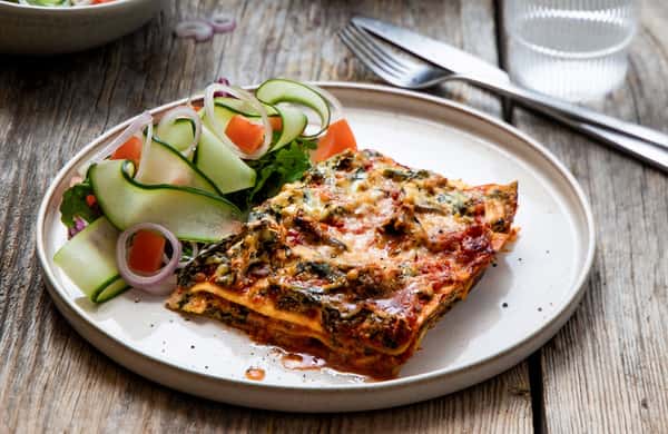 Vegetarlasagne med spinat- og crème fraîchesaus og agurk- og tomatsalat