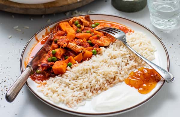 Indisk kyllinggryte med grønne erter, fullkornsris, mangochutney og yoghurt