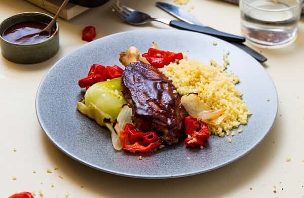 Barbecueglasert svineknoke med bakte grønnsaker og bulgur