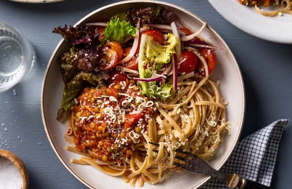 Rask bolognese med linser, fullkornslinguine, tomatsalat og revet Grande Premium