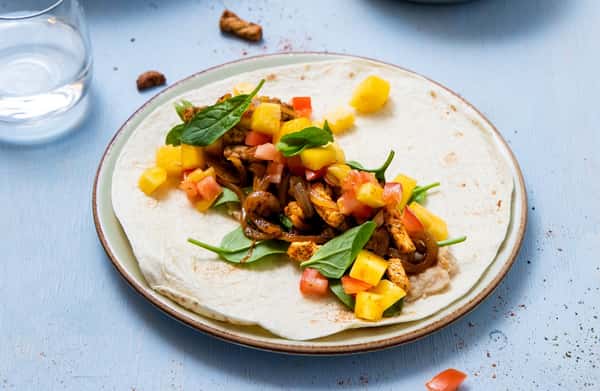 Fullkornstortilla med tacokrydret svin, bønnekrem og mango