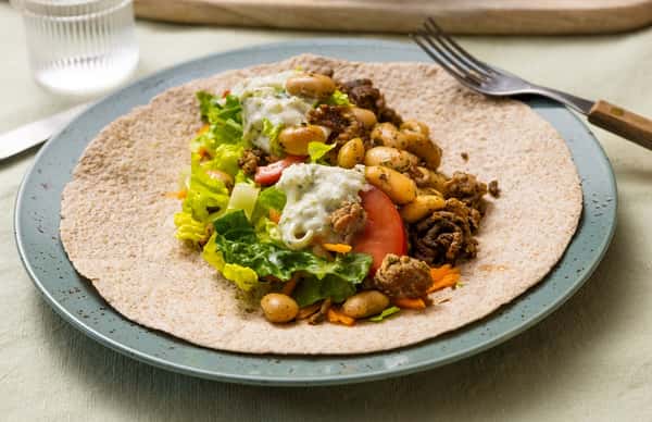 Fullkornstortilla med urtestekt kjøttdeig av storfe og svin, grønn salat og epletzatziki